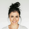 Woman with styled hair against a plain background